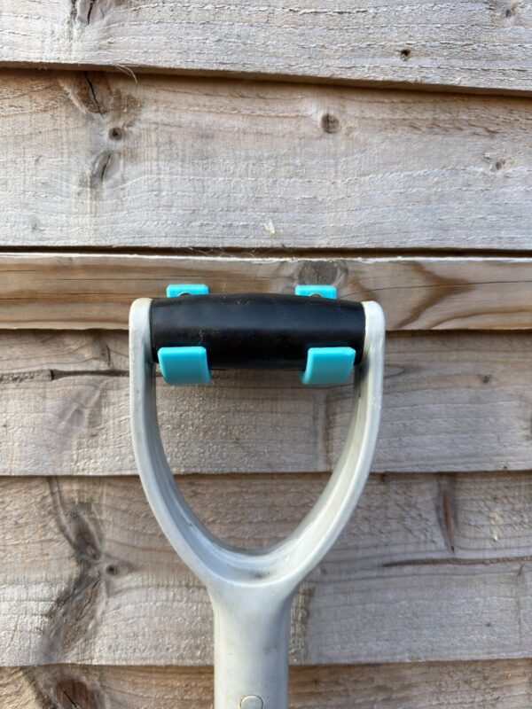 Garden Tool Storage Ideas for Small Sheds 1 Two turquoise garden tool hooks supporting the cross-grip of a garden tool on timber boards
